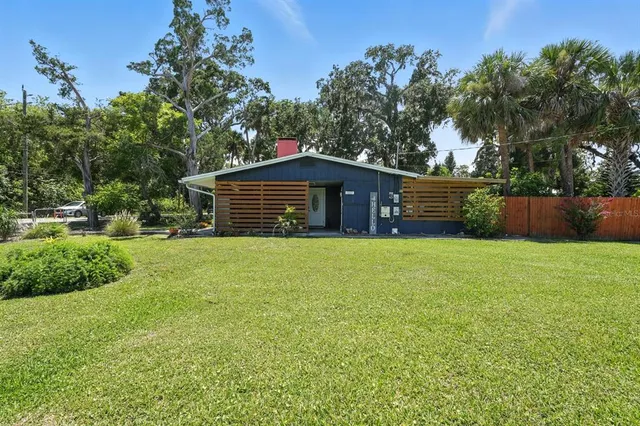 a front view of house with yard and trees in the background