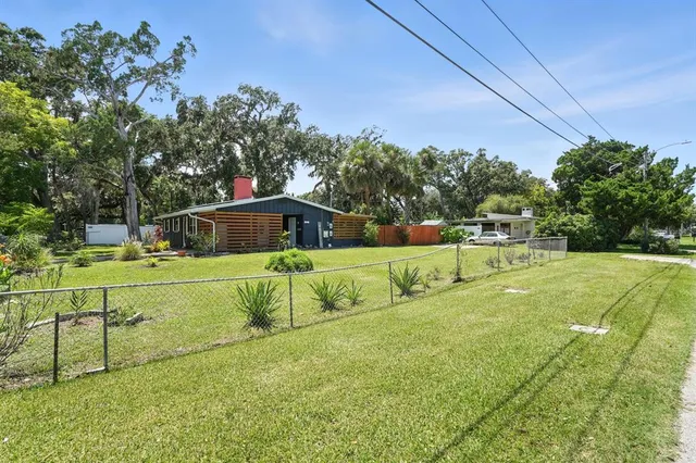 a backyard of a house with wooden fence and a yard