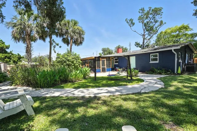 a view of a house with a yard and plant in front of it