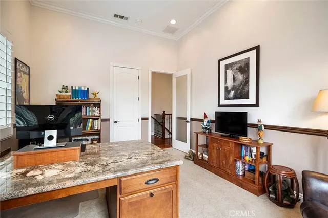 a bedroom with a bed and a flat tv screen on the dresser