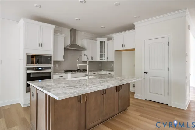 a kitchen with stainless steel appliances granite countertop a stove a refrigerator a sink and a microwave