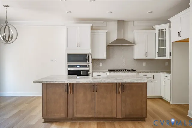 a kitchen with stainless steel appliances granite countertop a sink a stove and a refrigerator