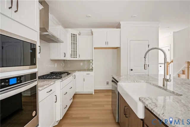 a kitchen with granite countertop a stove and a wooden floor