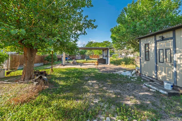 a view of a house with backyard and sitting area