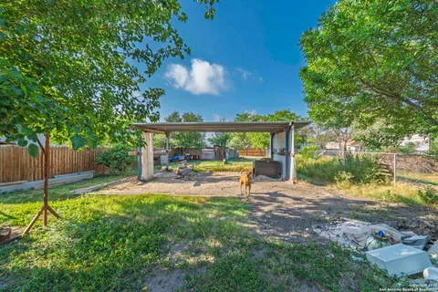 a view of a chair and table in backyard of the house