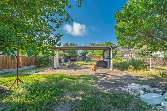 a view of a chair and table in backyard of the house