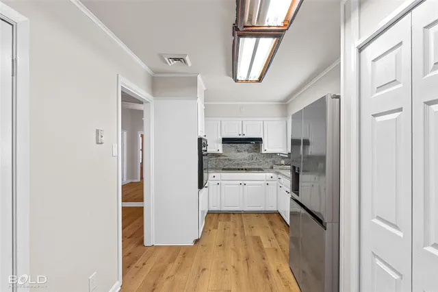 a kitchen with a refrigerator a sink and a stove top oven
