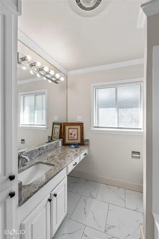 a bathroom with a granite countertop sink a mirror and a vanity