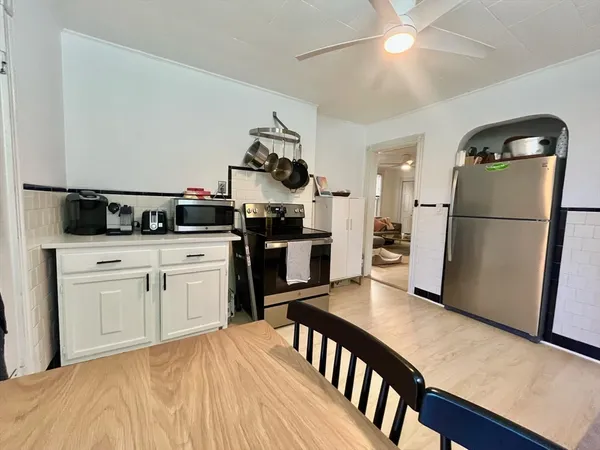 a kitchen with stainless steel appliances granite countertop a refrigerator a stove a sink dishwasher and a refrigerator with wooden floor