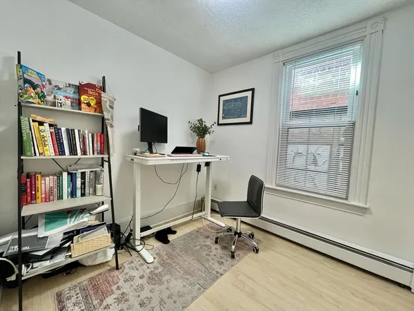 a view of a workspace with furniture and a window