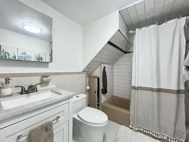 a bathroom with a sink a toilet and shower curtain