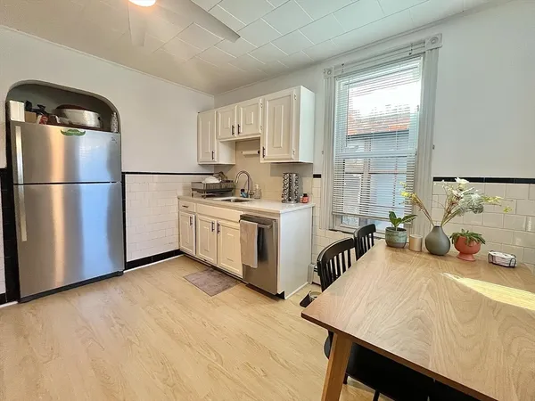 a kitchen with a refrigerator a stove a sink and a window