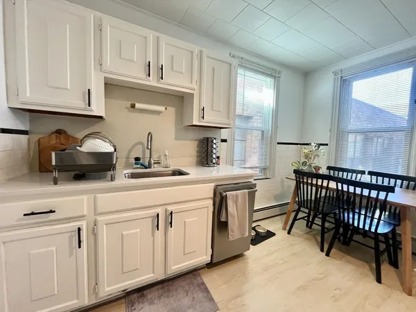 a kitchen with white cabinets and white appliances