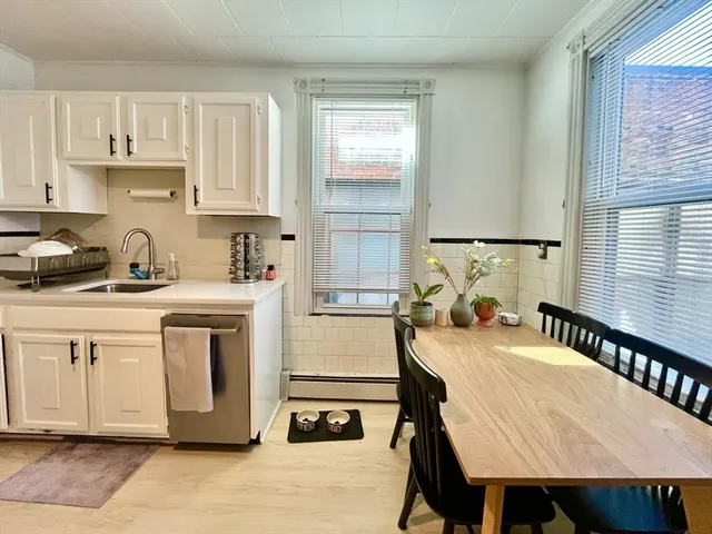 a kitchen with a stove a sink a dining table and chairs