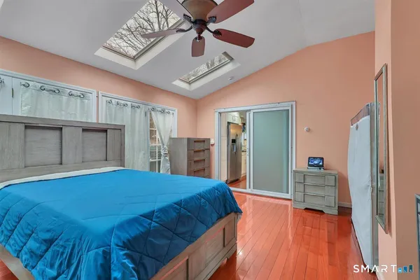 a bedroom with a large bed a flat tv screen and dresser