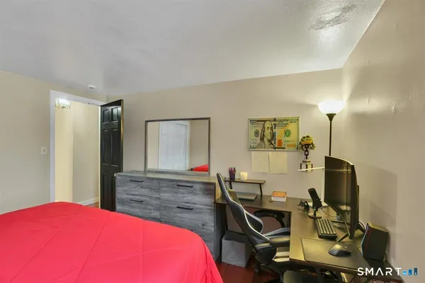 a bedroom with a bed and wooden floor
