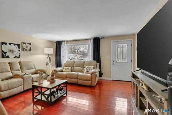 a living room with furniture a wooden floor and a window
