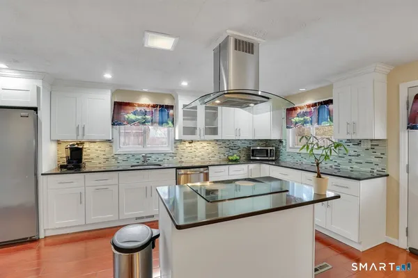 a kitchen with stainless steel appliances granite countertop a sink and a stove