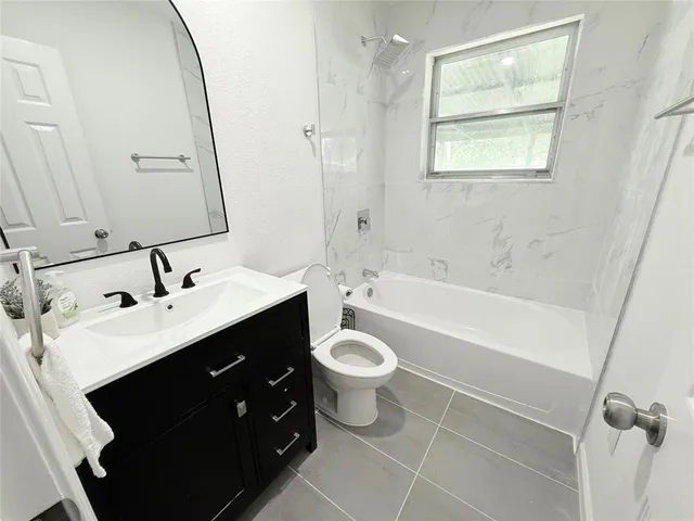 a bathroom with a double vanity sink toilet mirror and bathtub