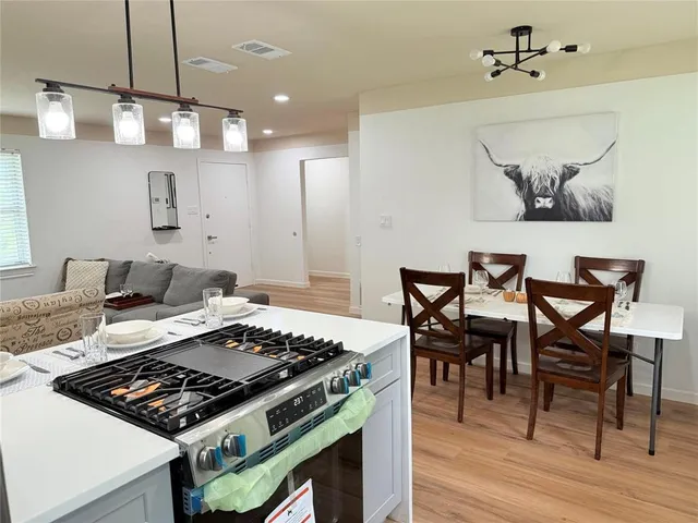 a kitchen with a stove and wooden floor