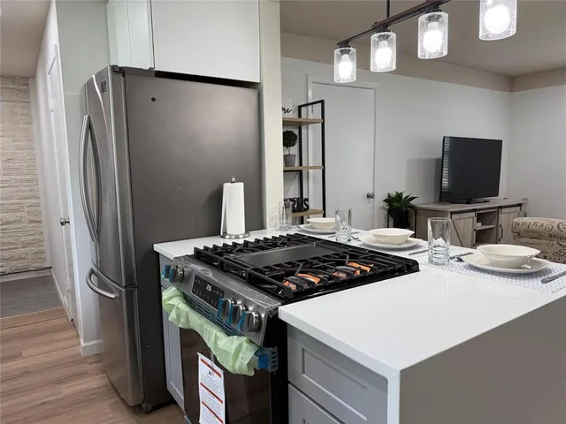 a kitchen with stainless steel appliances granite countertop a stove a refrigerator and a refrigerator