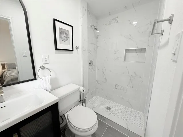 a white toilet sitting next to a bathroom sink