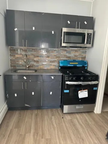 a kitchen with stainless steel appliances granite countertop a stove a microwave and a sink