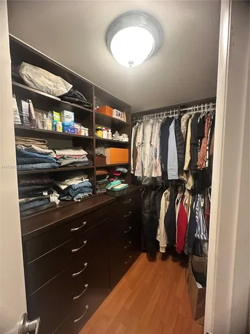 a view of walk in closet with clothes and shoes