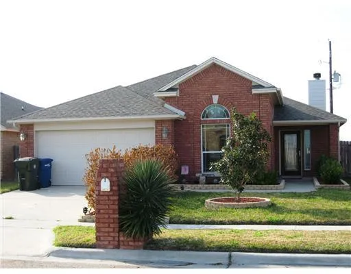 a front view of a house with a yard and potted plants