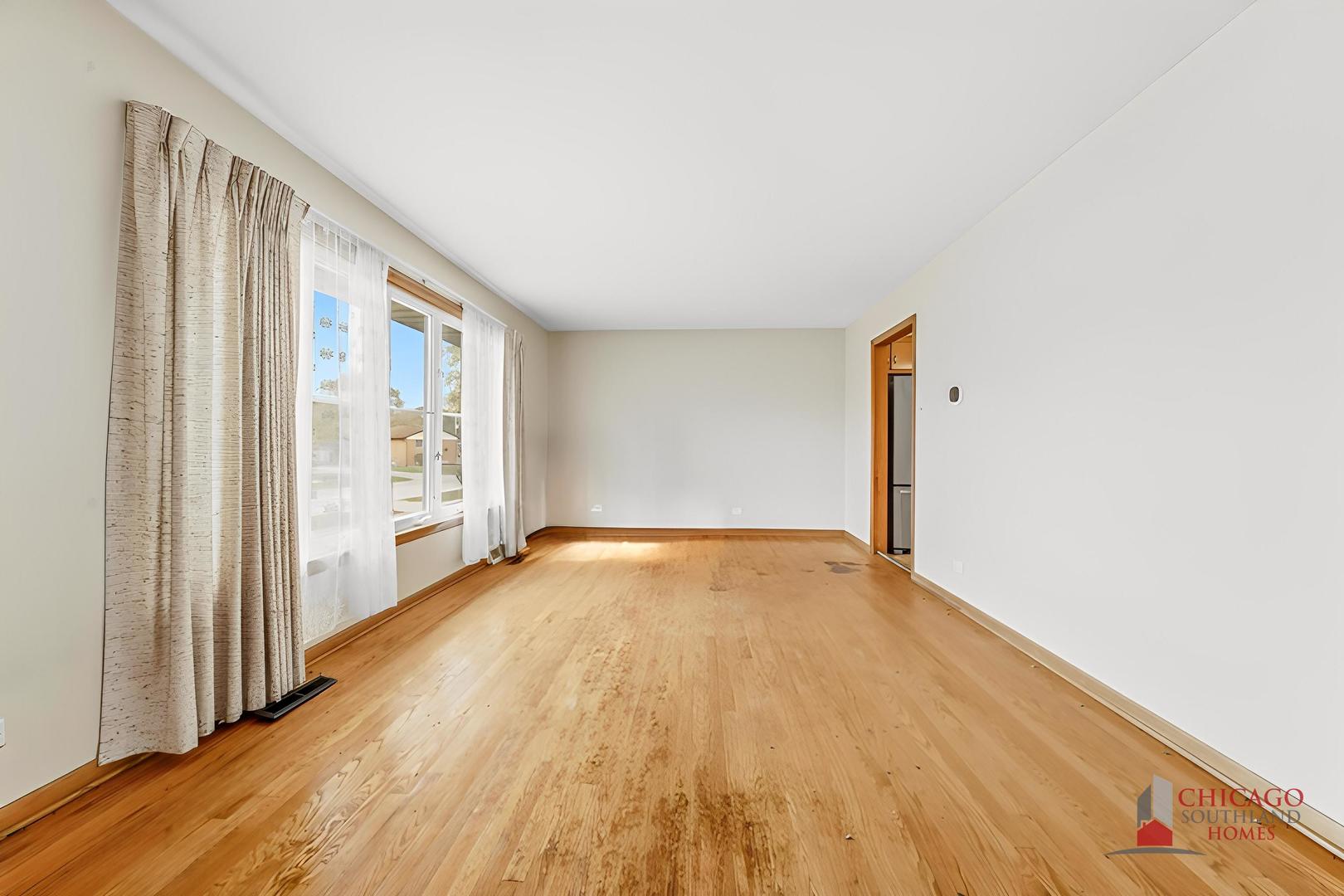 22 Charing Cross Road Chicago Heights, IL 60411 - Photo 13 of 25 a view of an empty room with wooden floor and a window