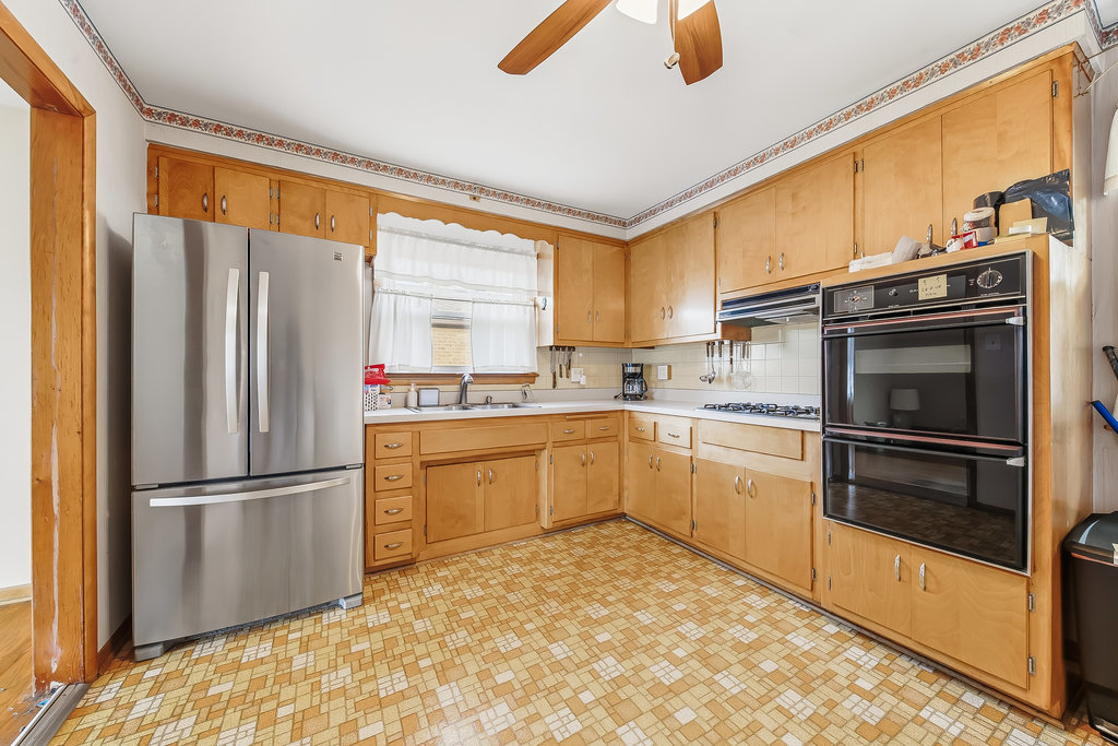 22 Charing Cross Road Chicago Heights, IL 60411 - Photo 8 of 25 a kitchen with a refrigerator stainless steel appliances wooden floor and window