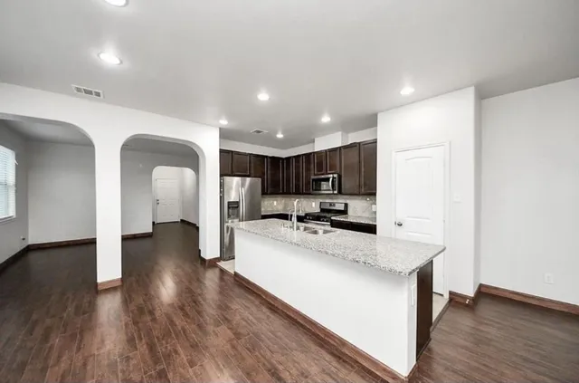 a kitchen with a sink cabinets and wooden floor