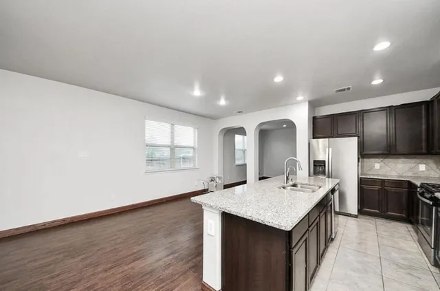 a view of empty room with wooden floor and ceiling fan