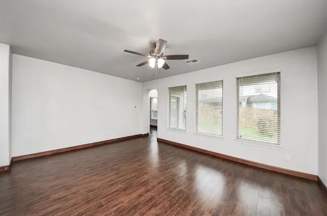 a view of wooden floor and a chandelier fan in a room