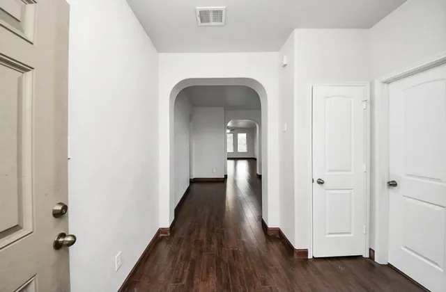 a view of a hallway with wooden floor