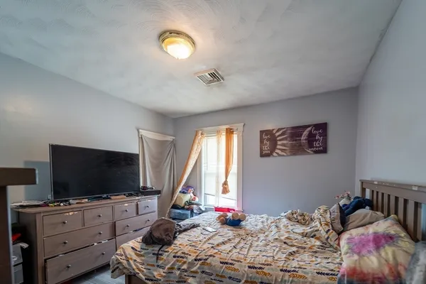 a bedroom with a bed and flat screen tv