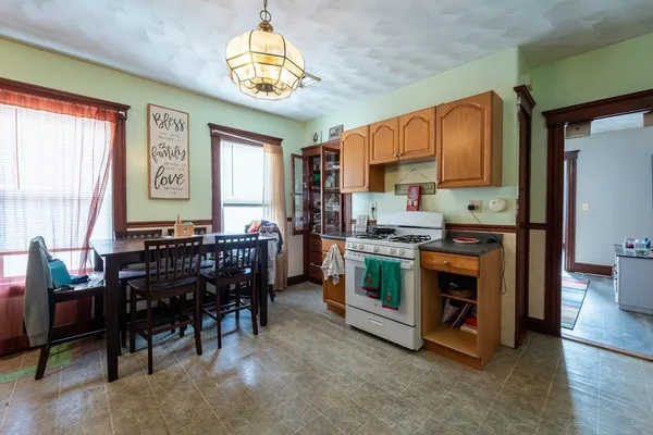 a kitchen with stainless steel appliances a stove a sink a microwave a dining table and chairs