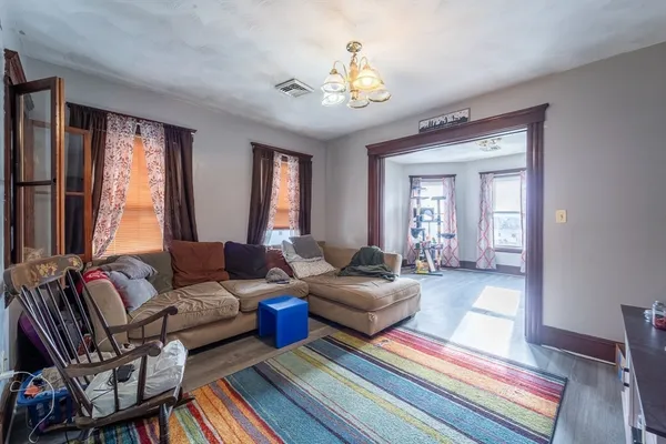 a living room with furniture and a chandelier