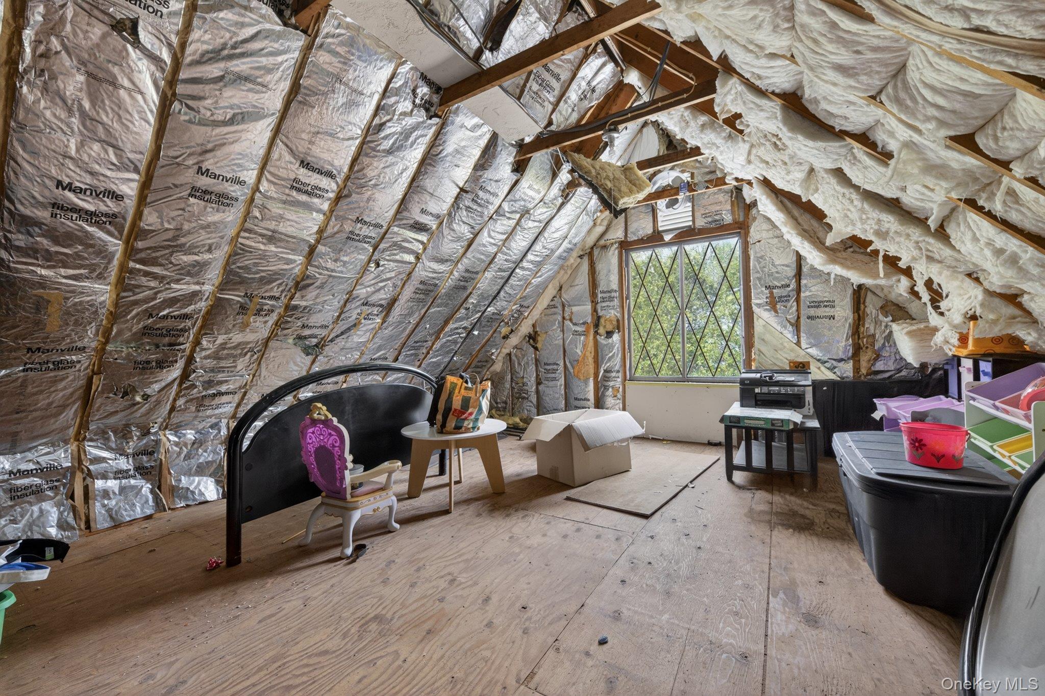 137 Blue Hill Road Hopewell Junction, NY 12533 - Photo 31 of 44 Attic space featuring exposed wood framing, foil-faced insulation, a diamond-pane window, and plywood subflooring