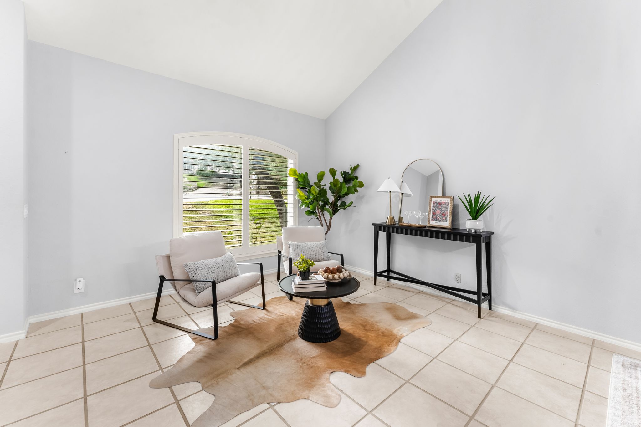 3704 Caney Creek Road Austin, TX 78732 - Photo 7 of 40 A well-lit sitting area features vaulted ceilings, arched windows, and tiled flooring.