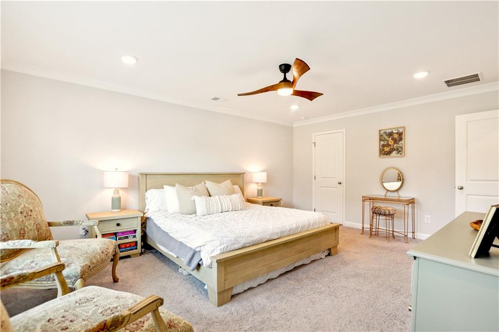 765 Trevett Way Marietta, GA 30066 - Photo 23 of 46 a bedroom with a bed a couch and a dresser with wooden floor