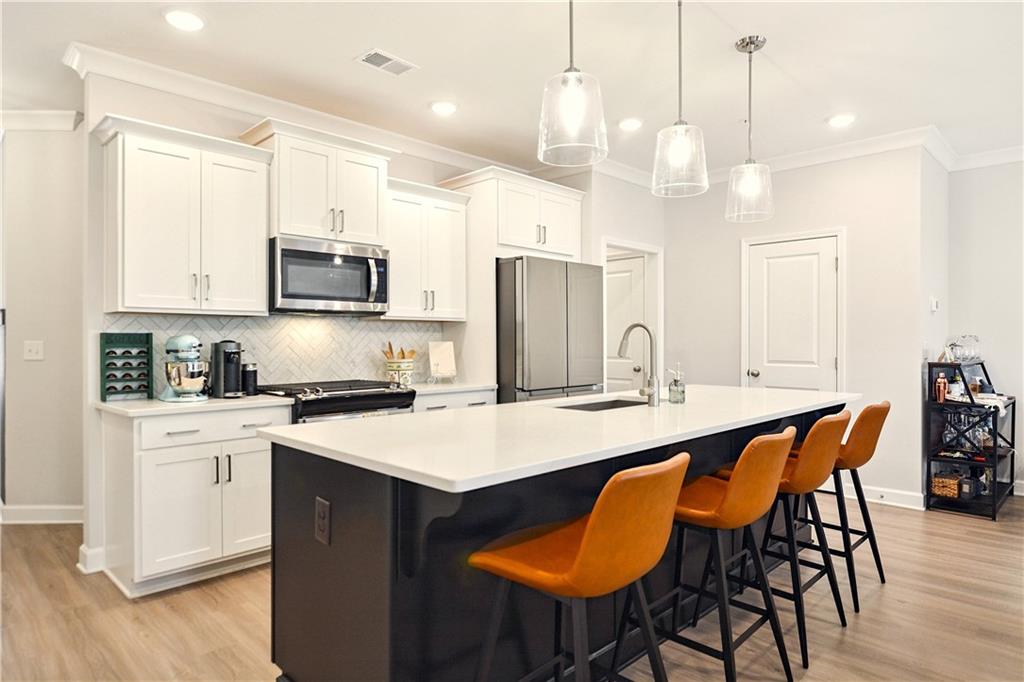 765 Trevett Way Marietta, GA 30066 - Photo 3 of 46 a kitchen with stainless steel appliances a stove a sink a refrigerator a kitchen island a table and chairs