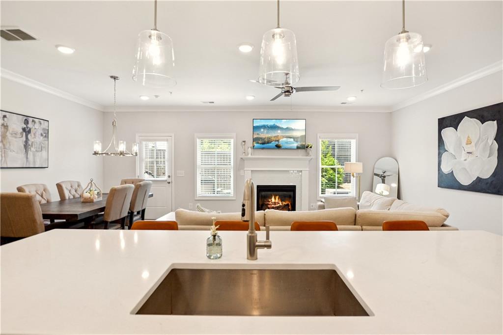 765 Trevett Way Marietta, GA 30066 - Photo 6 of 46 a large white kitchen with a large island oven a flat screen tv and couches