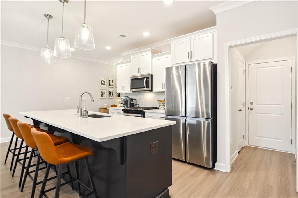 765 Trevett Way Marietta, GA 30066 - Photo 9 of 46 a kitchen with stainless steel appliances a sink a refrigerator a kitchen island and chairs in it