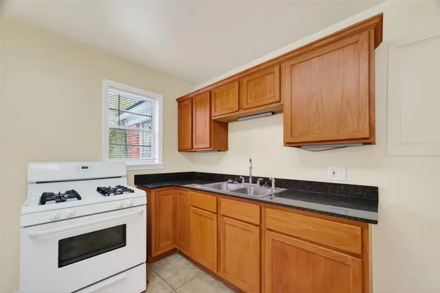 a kitchen with stainless steel appliances granite countertop a sink stove and cabinets