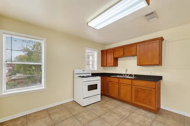a kitchen with stainless steel appliances granite countertop a stove a sink and a microwave
