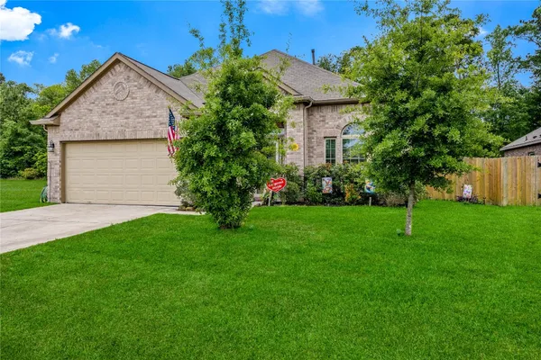 a front view of a house with a yard and a garden