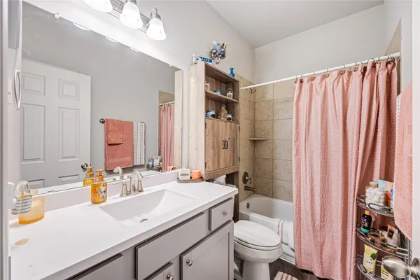 a bathroom with a sink a toilet and shower curtain