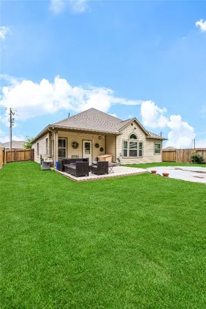 a view of house with yard and outdoor seating