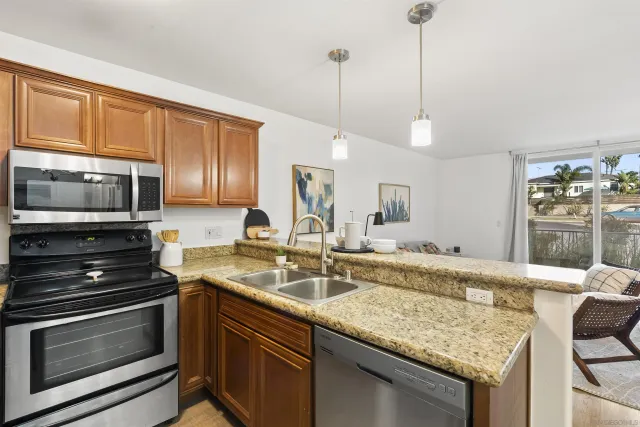 a kitchen with stainless steel appliances granite countertop a sink stove and microwave